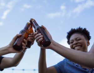 un plano medio de tres botellas sostenidas por un grupo de amigos
