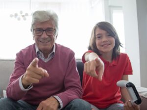 un señor mayor sonriendo y señalando a la cámara